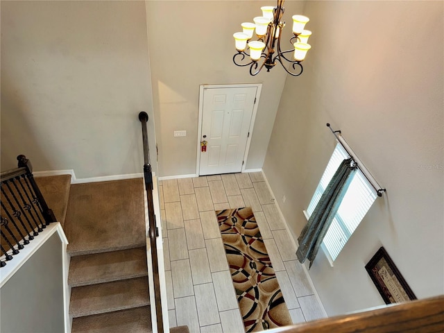 entryway featuring a towering ceiling and an inviting chandelier