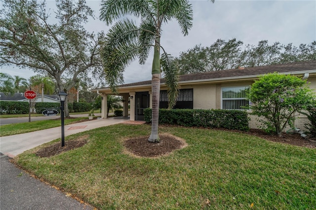 single story home featuring a carport and a front lawn