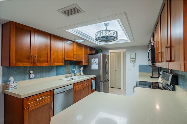 kitchen with kitchen peninsula, appliances with stainless steel finishes, backsplash, and sink