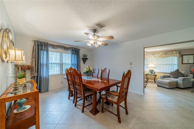 dining space featuring ceiling fan, a textured ceiling, and light tile patterned floors