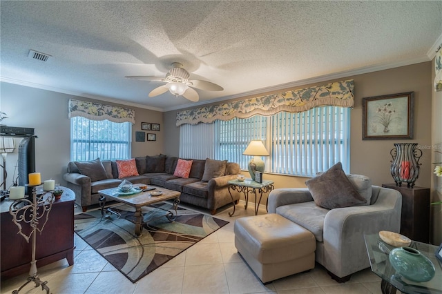 living room featuring light tile patterned flooring, a textured ceiling, ornamental molding, and ceiling fan