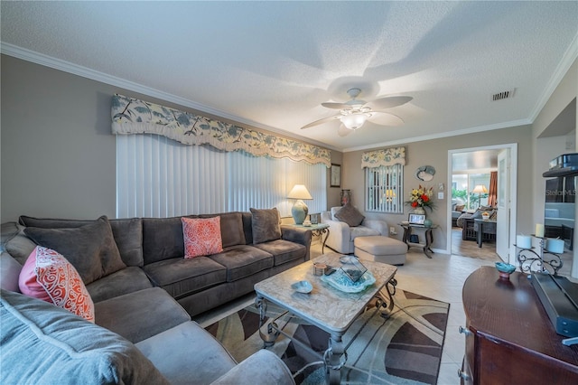 tiled living room featuring a textured ceiling, ceiling fan, and crown molding