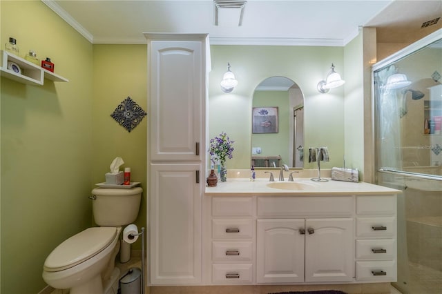 bathroom featuring a shower with door, crown molding, vanity, and toilet