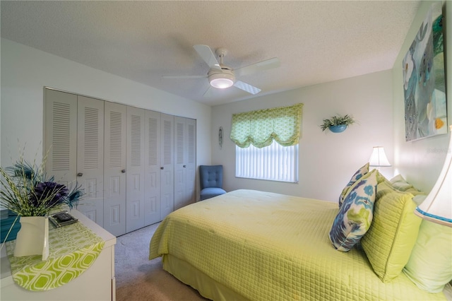 carpeted bedroom featuring a textured ceiling, ceiling fan, and a closet