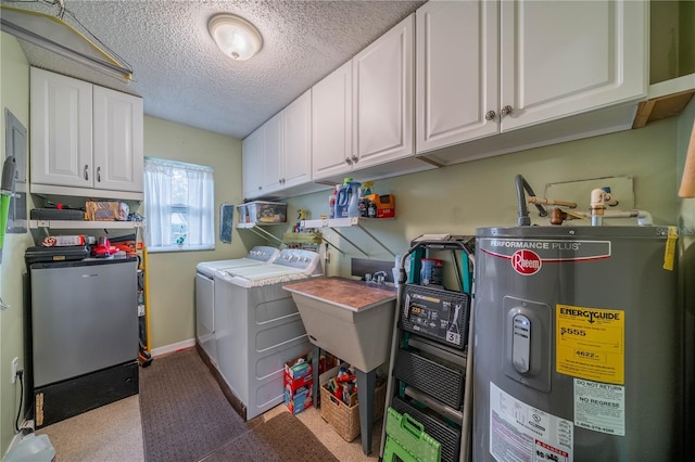 washroom with sink, a textured ceiling, cabinets, water heater, and washer and dryer