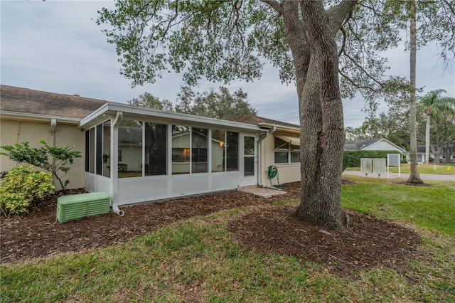 view of front of property with a sunroom and a front lawn