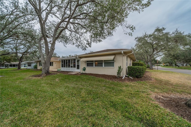 back of house with a lawn and a sunroom