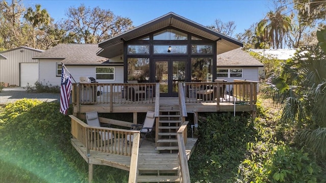 back of property with a wooden deck and a sunroom