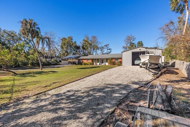 view of front of house featuring an outbuilding, a front lawn, and a garage