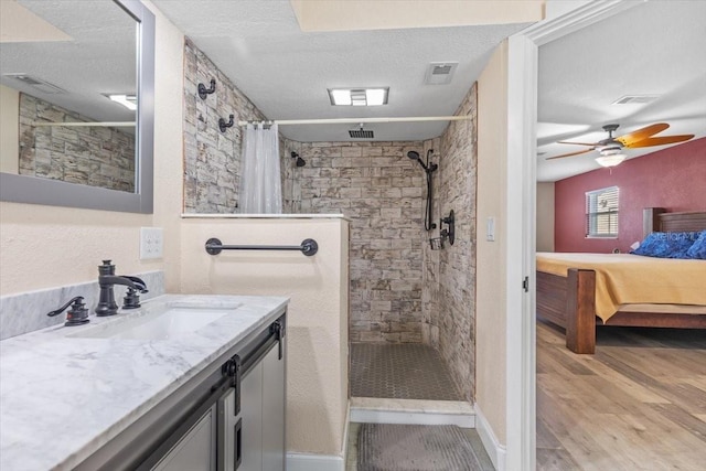 bathroom with hardwood / wood-style floors, ceiling fan, a textured ceiling, and walk in shower