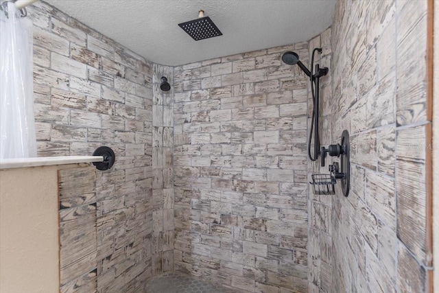 bathroom with a textured ceiling and tiled shower