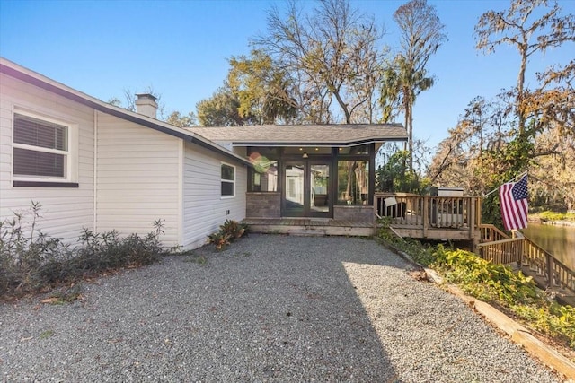 exterior space featuring a wooden deck and a sunroom