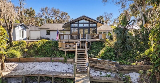 rear view of property featuring an outdoor structure and a wooden deck