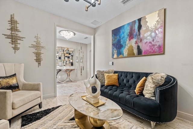 living room with an inviting chandelier and a textured ceiling