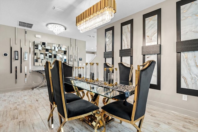 dining room featuring an inviting chandelier, a textured ceiling, and light hardwood / wood-style flooring