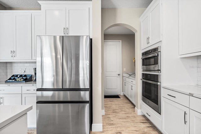 kitchen with white cabinets, a textured ceiling, and appliances with stainless steel finishes