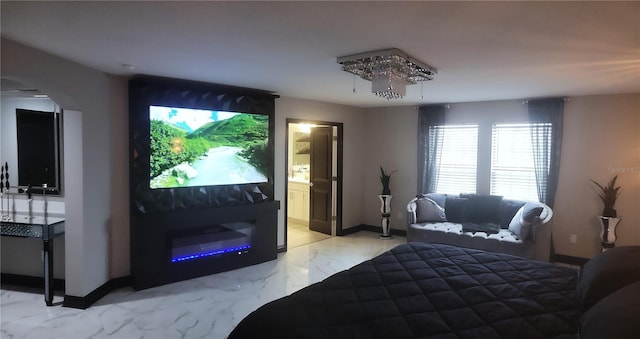 bedroom featuring ensuite bath and a chandelier