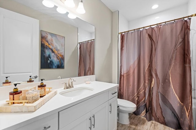 bathroom with hardwood / wood-style floors, toilet, and vanity