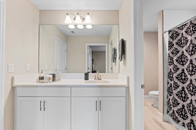 bathroom with toilet, vanity, a shower with curtain, and hardwood / wood-style flooring