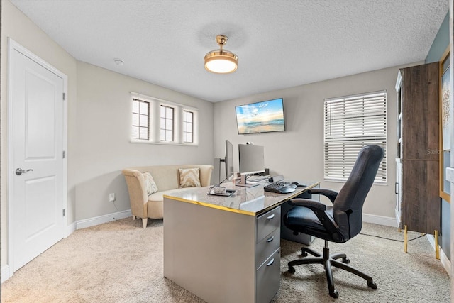 office space featuring a textured ceiling, light colored carpet, and plenty of natural light