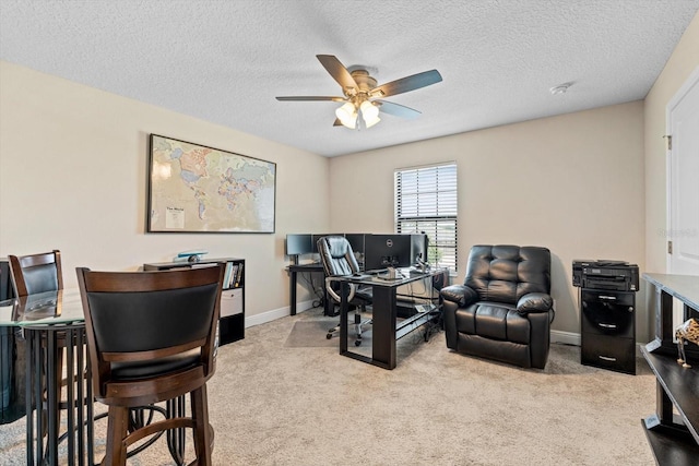 carpeted home office with ceiling fan and a textured ceiling