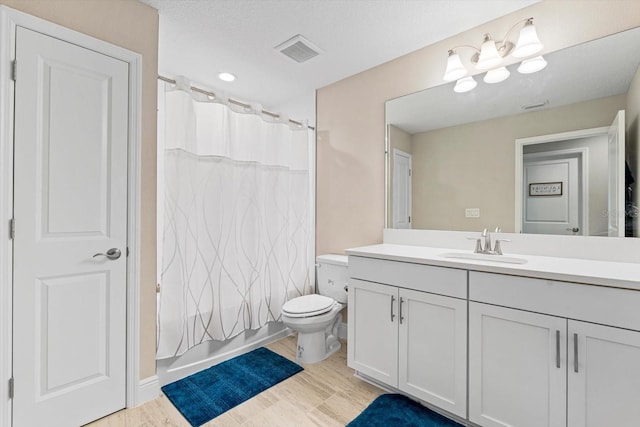 full bathroom featuring toilet, vanity, shower / bath combo, hardwood / wood-style flooring, and a textured ceiling