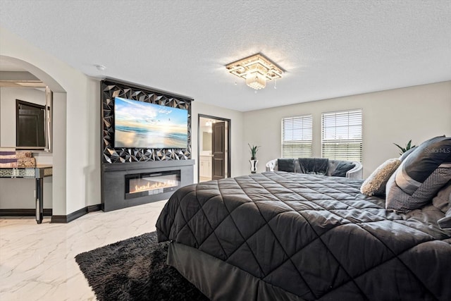 bedroom featuring connected bathroom and a textured ceiling