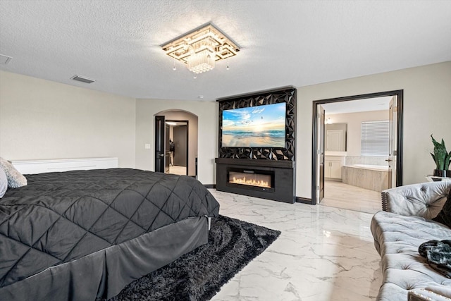 bedroom with a textured ceiling and connected bathroom