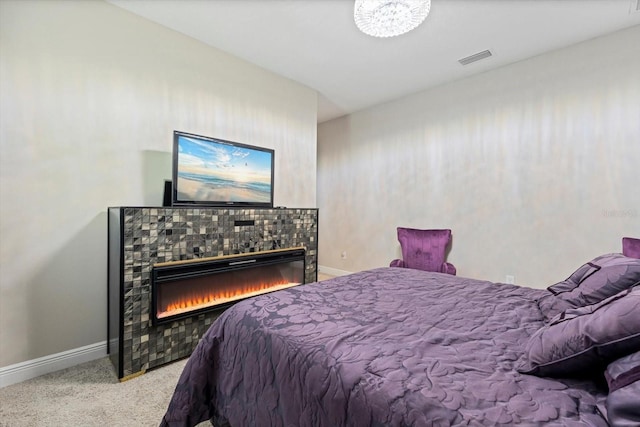 carpeted bedroom featuring a tiled fireplace