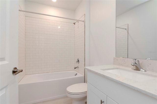 full bathroom with toilet, tiled shower / bath, and vanity