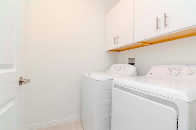 laundry room featuring cabinets and washing machine and dryer