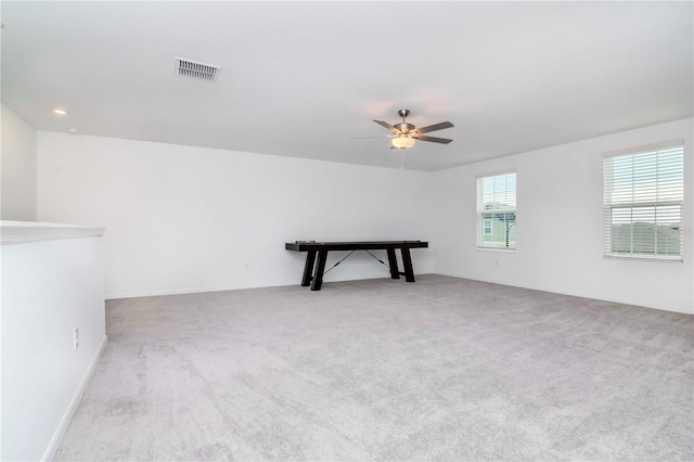 carpeted spare room with ceiling fan