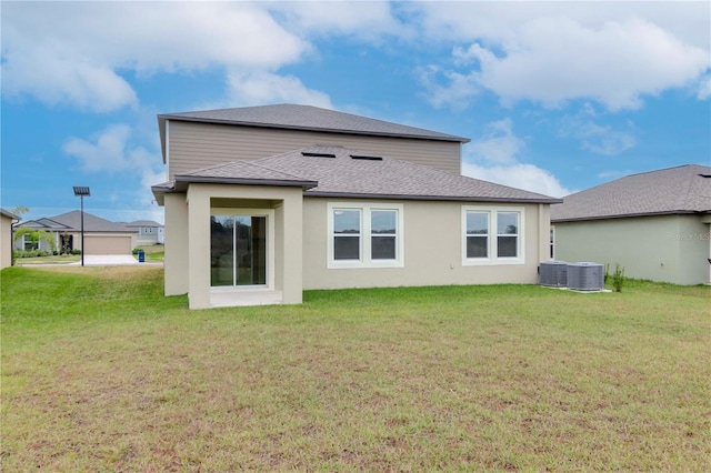 rear view of property with central AC and a lawn