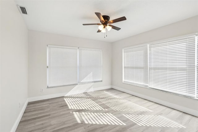 spare room with ceiling fan, a healthy amount of sunlight, and light wood-type flooring