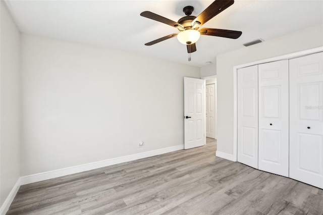 unfurnished bedroom with a closet, light hardwood / wood-style flooring, and ceiling fan