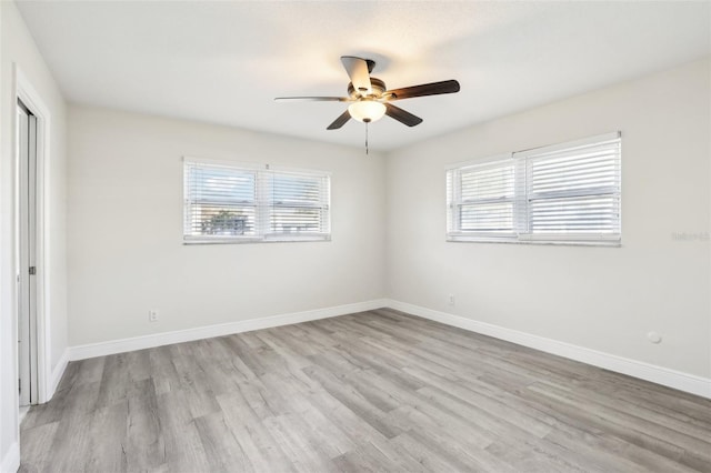 spare room featuring ceiling fan, light hardwood / wood-style flooring, and a healthy amount of sunlight