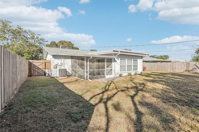 back of house with a lawn, central air condition unit, and a sunroom