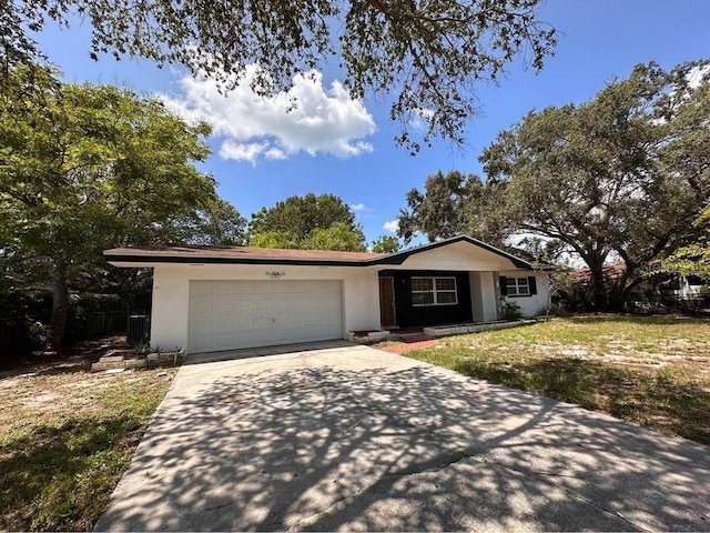 single story home with a garage and a front lawn