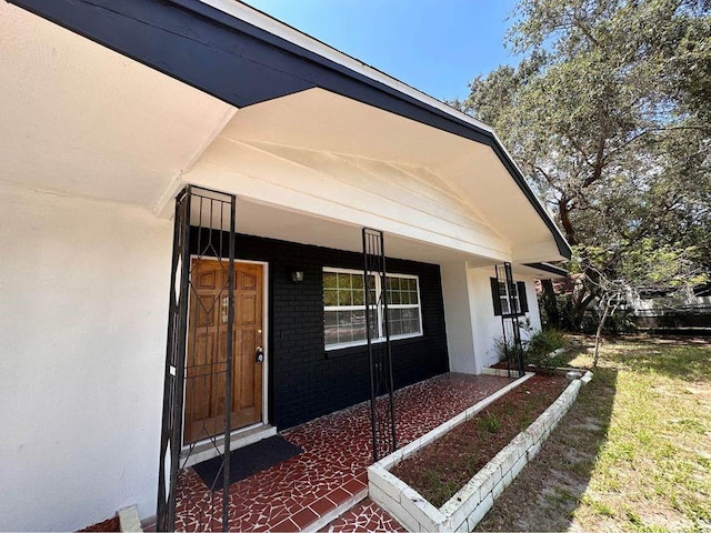 view of exterior entry with a porch