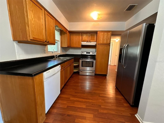 kitchen with backsplash, dark hardwood / wood-style flooring, sink, and stainless steel appliances