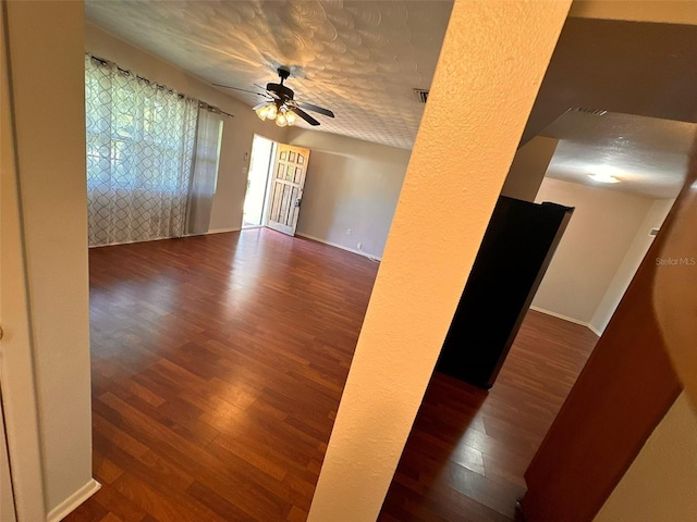 spare room featuring ceiling fan, a textured ceiling, and dark wood-type flooring