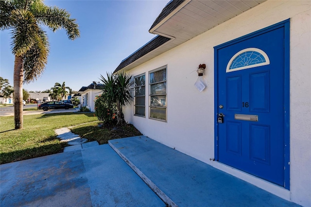 entrance to property featuring a lawn