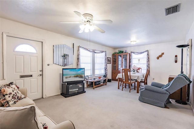 carpeted living room with ceiling fan