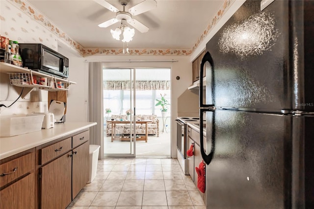 kitchen with electric stove, black fridge, ceiling fan, and light tile patterned floors