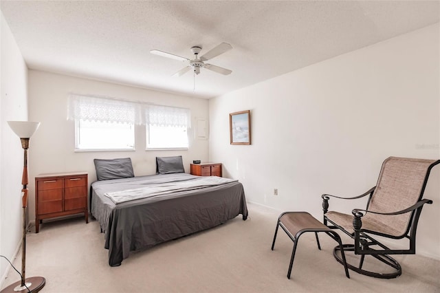 bedroom with a textured ceiling, ceiling fan, and light carpet