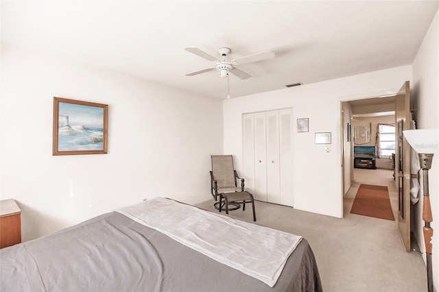 bedroom featuring ceiling fan, light colored carpet, and a closet