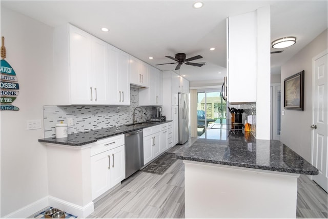 kitchen featuring kitchen peninsula, ceiling fan, white cabinetry, and stainless steel appliances