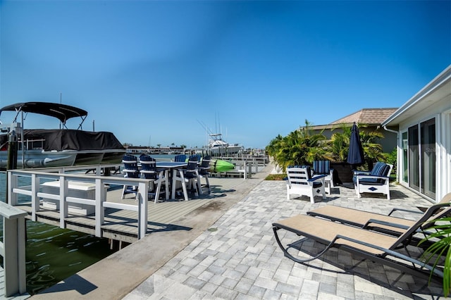 view of dock featuring a patio area and a water view