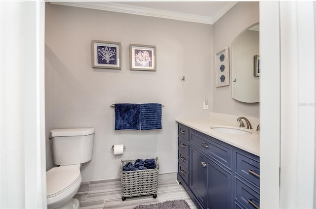 bathroom featuring ornamental molding, vanity, and toilet