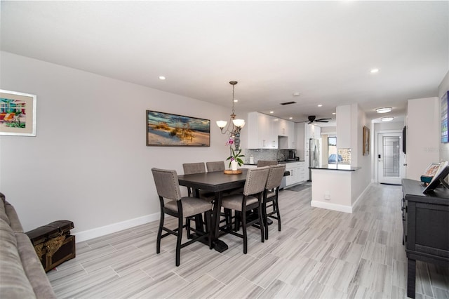 dining space with ceiling fan with notable chandelier